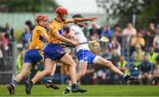 27 May 2018; Waterford full back Barry Coughlan kicks the sliothar, out for a '65', under pressure from Peter Duggan and John Conlon of Clare, 11, during the Munster GAA Hurling Senior Championship Round 2 match between Clare and Waterford at Cusack Park in Ennis, Co Clare. Photo by Ray McManus/Sportsfile