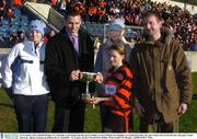 21 November 2003; Danielle Brogan, St. Colmcilles, is presented with the cup by Dublin's Ciaran Whelan, the daughters of Austin Finn Orla, left, and Yvonne and son Declan after the game. Austin Finn Cup, Allianz Cumann na mBunscoil, St. Colmcilles v St. Francis Xaviers, Parnell Park, Dublin. Picturecredit; Pat Murphy / SPORTSFILE *EDI*