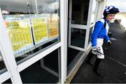 15 March 2020; A view of an advisory sign regarding Coronavirus (COVID-19) as jockey Mark Enright makes his way to the parade ring prior to the Follow Limerick Racecourse On Facebook Hurdle at Limerick Racecourse in Patrickswell, Limerick. Photo by Seb Daly/Sportsfile