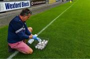 17 July 2020; St Martin's kitman Mick Reade sanitises the sliotars prior the Wexford County Senior Hurling Championship Group A Round 1 match between Oulart the Ballagh and St Martin's at Chadwicks Wexford Park in Wexford. Competitive GAA matches have been approved to return following the guidelines of Phase 3 of the Irish Government’s Roadmap for Reopening of Society and Business and protocols set down by the GAA governing authorities. With games having been suspended since March, competitive games can take place with updated protocols including a limit of 200 individuals at any one outdoor event, including players, officials and a limited number of spectators, with social distancing, hand sanitisation and face masks being worn by those in attendance among other measures in an effort to contain the spread of the Coronavirus (COVID-19) pandemic. Photo by Brendan Moran/Sportsfile