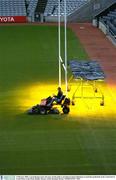 2 February 2004; A groundsman mows the grass on the pitch as greenhouse lamps illuminate around the goalmouth at the Canal End of Croke Park. Croke Park, Dublin. Picture credit; Brendan Moran / SPORTSFILE *EDI*