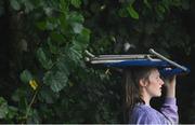 10 September 2021; A spectator uses a chair to take shelter from heavy rain during match two of the Dafanews International Cup ODI series between Ireland and Zimbabwe at Stormont in Belfast. Photo by Ramsey Cardy/Sportsfile