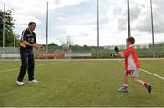 27 July 2013; Kildare footballer John Doyle and former Kilkenny hurler Martin Comerford supporting the Opel Kit for Clubs Blitz Day in St. Brigids GAA Club, Blanchardstown. Kildare footballer John Doyle gives instructions to a St. Brigids GAA Club, Blanchardstown, player on hand passing during a skills session. For every test drive, car service or Opel purchase made through the Opel dealer network, your local GAA club is awarded points. Build up your points and redeem them against high quality kit for your club! Log onto opelkitforclubs.com http://opelkitforclubs.com and start earning points today.  Support your local GAA club! St. Brigid's GAA Club, Blanchardstown, Dublin. Picture credit: Barry Cregg / SPORTSFILE