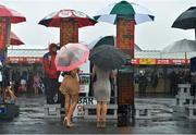 1 August 2013; Two racegoers study the betting odds ahead of the Perfect Pint Beginners Steeplechase. Galway Racing Festival, Ballybrit, Co. Galway. Picture credit: Barry Cregg / SPORTSFILE