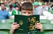 26 March 2022; Republic of Ireland supporter Maxim Tkac Saeo, aged 11, from Wicklow town, reads the match programme before the international friendly match between Republic of Ireland and Belgium at the Aviva Stadium in Dublin. Photo by Eóin Noonan/Sportsfile