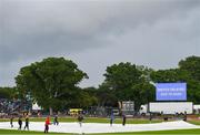 26 June 2022; Rain covers are pulled onto the pitch during a rain delay at the LevelUp11 First Men's T20 International match between Ireland and India at Malahide Cricket Club in Dublin. Photo by Ramsey Cardy/Sportsfile