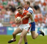 23 May 2004; Martin O'Rourke, Armagh, is tackled by Eoin Lennon, Monaghan. Bank of Ireland Ulster Senior Football Championship, Monaghan v Armagh, St. Tighernach's Park, Clones, Co. Monaghan. Picture credit; Pat Murphy / SPORTSFILE