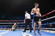 10 December 2022; Michael Conlan knocks down Karim Guerfi in the first round of their featherweight bout at the SSE Arena in Belfast. Photo by Ramsey Cardy/Sportsfile
