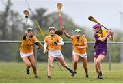 22 April 2023; Erin McDonald of Wexford in action against Antrim players, from left, Abi McNeill, Shannagh Heggarty, and Erin Coulter during the Electric Ireland Camogie Minor A Shield Semi-Final match between Antrim and Wexford at Coralstown Kinnegad GAA in Westmeath. Photo by Stephen Marken/Sportsfile