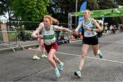 23 April 2023; Iseult O'Donnell of Raheny Shamrock AC, Dublin, left, takes over from team-mate Niamh Kearney whilst competing in the senior women's event during the 123.ie National Road Relay Championships at Raheny in Dublin. Photo by Sam Barnes/Sportsfile