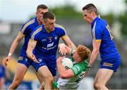 20 May 2023; Oisin Gallen of Donegal is tackled by Clare players, Cillian Brennan, 3, Eoin Cleary, right, and Emmet McMahon during the GAA Football All-Ireland Senior Championship Round 1 match between Clare and Donegal at Cusack Park in Ennis, Clare. Photo by Ray McManus/Sportsfile