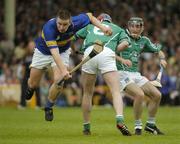 26 June 2004; John Carroll, Tipperary, is tackled by Brian Geary, Limerick. Guinness Senior Hurling Championship Qualifier, Round 1, Limerick v Tipperary, Gaelic Grounds, Limerick. Picture credit; Pat Murphy / SPORTSFILE