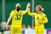 28 July 2023; Australia bowler Ashleigh Gardner, right, is congratulated by teammate Tahlia McGrath after claiming the wicket of Ireland's Cara Murray during match three of the Certa Women’s One Day International Challenge series between Ireland and Australia at Castle Avenue Cricket Ground in Dublin. Photo by Seb Daly/Sportsfile
