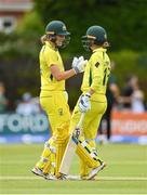 28 July 2023; Australia batter Annabel Sutherland, left, is congratulated by teammate Phoebe Litchfield after bringing up her half-century of runs during match three of the Certa Women’s One Day International Challenge series between Ireland and Australia at Castle Avenue Cricket Ground in Dublin. Photo by Seb Daly/Sportsfile