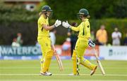 28 July 2023; Australia batter Annabel Sutherland, left, is congratulated by teammate Phoebe Litchfield after bringing up her half-century of runs during match three of the Certa Women’s One Day International Challenge series between Ireland and Australia at Castle Avenue Cricket Ground in Dublin. Photo by Seb Daly/Sportsfile