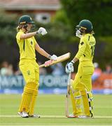 28 July 2023; Phoebe Litchfield of Australia, right, is congratulated by teammate Annabel Sutherland after bringing up her century of runs during match three of the Certa Women’s One Day International Challenge series between Ireland and Australia at Castle Avenue Cricket Ground in Dublin. Photo by Seb Daly/Sportsfile