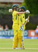 28 July 2023; Phoebe Litchfield of Australia, right, is congratulated by teammate Annabel Sutherland after bringing up her century of runs during match three of the Certa Women’s One Day International Challenge series between Ireland and Australia at Castle Avenue Cricket Ground in Dublin. Photo by Seb Daly/Sportsfile