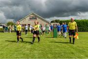 19 August 2023; Referee Sarah Dyas, assistant referee Hannah O'Brien and assistant referee John Hayes lead the teams onto the field before the FAI Women’s Amateur Shield Final 2023 match between St Patrick’s CYFC and Wilton United at Newhill Park in Two Mile Borris, Tipperary. Photo by Tom Beary/Sportsfile