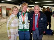 11 December 2023; Ireland’s European Cross Country Team returning to Dublin Airport this morning following another hugely successful competition in Brussels yesterday. The returning team including U20 men's 5000m team gold medallist Shane Brosnan, centre, with his grandparents Catherine and Denis. Photo by Ben McShane/Sportsfile