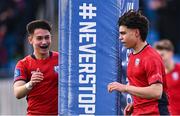 25 January 2024; Mark Murray of CUS celebrates with teammate David Li, left, after scoring their side's third try during the Bank of Ireland Leinster Rugby Schools Father Godfrey Cup semi-final match between Good Counsel, New Ross and CUS at Energia Park in Dublin. Photo by Ben McShane/Sportsfile