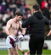 25 February 2024; Cathal Sweeney of Galway changes his jersey  after being ripped during the Allianz Football League Division 1 match between Galway and Derry at Pearse Stadium in Galway. Photo by Ray Ryan/Sportsfile