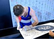 11 March 2024; Jude Gallagher of Ireland, signing an autograph after winning their Men's 57kg Quarterfinals bout against Shukur Ovezov of Turkmenistan during day nine at the Paris 2024 Olympic Boxing Qualification Tournament at E-Work Arena in Busto Arsizio, Italy. Photo by Ben McShane/Sportsfile