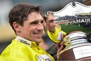 14 March 2024; Jockey Harry Skelton celebrates with the trophy after riding Protektorat to victory in the Ryanair Chase on day three of the Cheltenham Racing Festival at Prestbury Park in Cheltenham, England. Photo by David Fitzgerald/Sportsfile