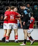 22 March 2024; Seán O'Brien of Munster celebrates with team-mates Antoine Frisch, left, Mike Haley, 15, and Craig Casey, right, after scoring his side's third try during the United Rugby Championship match between Ospreys and Munster at the Swansea.com Stadium in Swansea, Wales. Photo by Gruffydd Thomas/Sportsfile