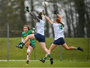 24 March 2024; Leah Fox of Leitrim takes a shot, under pressure from Limerick players Cathy Mee, left, and Fiona Bradshaw, during the Lidl LGFA National League Division 4 semi-final match between Leitrim and Limerick at Pádraig Pearses GAA Club in Roscommon. Photo by Seb Daly/Sportsfile