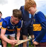 15 June 2024; Cathal O'Reilly of Tipperary signs the hurl of a young supporter after the Electric Ireland GAA Hurling All-Ireland Minor Hurling Championship semi-final match between Tipperary and Galway at TUS Gaelic Grounds in Limerick. Photo by Tom Beary/Sportsfile