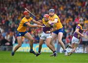 22 June 2024; Conor Hearne of Wexford is tackled by David Fitzgerald and Peter Duggan of Clare during the GAA Hurling All-Ireland Senior Championship quarter-final match between Clare and Wexford at FBD Semple Stadium in Thurles, Tipperary. Photo by Ray McManus/Sportsfile