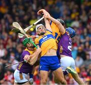 22 June 2024; Aron Shanagher of Clare is tackled by Matthew O'Hanlon, left, and Shane Reck of Wexford during the GAA Hurling All-Ireland Senior Championship quarter-final match between Clare and Wexford at FBD Semple Stadium in Thurles, Tipperary. Photo by Ray McManus/Sportsfile