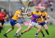 22 June 2024; Lee Chin of Wexford is tackled by Clare players, from left, Diarmuid Ryan and Conor Leen during the GAA Hurling All-Ireland Senior Championship quarter-final match between Clare and Wexford at FBD Semple Stadium in Thurles, Tipperary. Photo by John Sheridan/Sportsfile