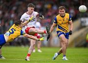 22 June 2024; Eoin McElhone of Tyrone kicks despite the attention of David Murray, left, and Enda Smith of Roscommon during the GAA Football All-Ireland Senior Championship preliminary quarter-final match between Tyrone and Roscommon at O'Neill's Healy Park in Omagh, Tyrone. Photo by Ben McShane/Sportsfile