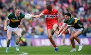 30 June 2024; Shane McGuigan of Derry scores a point despite the efforts of Jason Foley, left, and Tony Brosnan of Kerry during the GAA Football All-Ireland Senior Championship quarter-final match between Kerry and Derry at Croke Park in Dublin. Photo by Shauna Clinton/Sportsfile