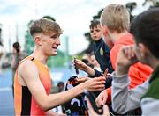 12 July 2024; Nick Griggs of Ireland signs autographs after finishing second in the Albie Thomas Family/ Dublin Athletics Board Men's 5000m with a new PB of 13:13.07 during the Morton Games at Morton Stadium in Dublin. Photo by Sam Barnes/Sportsfile