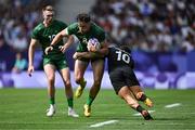 25 July 2024; Hugo Keenan of Team Ireland is tackled by Tepaea Cook-Savage of Team New Zealandduring the Men's Rugby Sevens Pool A match between Team Ireland and Team New Zealand at the Stade de France during the 2024 Paris Summer Olympic Games in Paris, France. Photo by Brendan Moran/Sportsfile