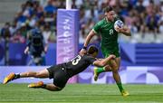25 July 2024; Hugo Keenan of Team Ireland is tackled by Joe Webber of Team New Zealand during the Men's Rugby Sevens Pool A match between Team Ireland and Team New Zealand at the Stade de France during the 2024 Paris Summer Olympic Games in Paris, France. Photo by Brendan Moran/Sportsfile