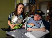 5 August 2024; Aishling O'Connell, herself a Garda in Killarney, from TG4 All-Ireland Ladies Senior Football Champions Kerry is pictured with the Brendan Martin Cup and 'Honorary Garda, Mikey Henry Bension during a visit by the players to Children's Health Ireland at Crumlin, Dublin.  Photo by Ray McManus/Sportsfile