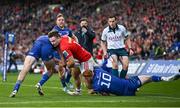 12 October 2024; Seán O’Brien of Munster is tackled by Leinster players Hugo Keenan, left, and Ciarán Frawley, 10, during the United Rugby Championship match between Leinster and Munster at Croke Park in Dublin. Photo by Seb Daly/Sportsfile