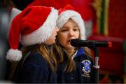 18 December 2024; Jasmine Stinca and Carmen Alegria-Walshe pupils in the first and second class of St Louis Primary School, Rathmines, entertain passengers as they arrive in Terminal 1 at Dublin Airport. Photo by Ray McManus/Sportsfile