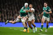 1 February 2025; Mack Hansen of Ireland is tackled by Cadan Murley, left, and Ollie Lawrence of England during the Guinness Six Nations Rugby Championship match between Ireland and England at Aviva Stadium in Dublin. Photo by Brendan Moran/Sportsfile