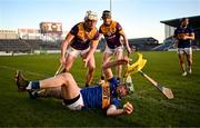 2 February 2025; Brian McGrath of Tipperary is shepherded over the sideline by Jack Redmond and Corey Byrne Dunbar of Wexford during the Allianz Hurling League Division 1A match between Tipperary and Wexford at FBD Semple Stadium in Thurles, Tipperary. Photo by Brendan Moran/Sportsfile