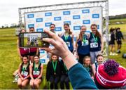 8 March 2025; The Institute of Education celebrate with the cup alongside second place finishers Sacred Heart Tullamore and third place finishers Abbey Community College in the Senior Girls 3,500m team event during the 123.ie All Ireland Schools Cross Country Championships at Galway Racecourse in Ballybrit, Galway. Photo by Tom Beary/Sportsfile