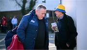 9 March 2025; Clare supporter John Corry, from Shannon Gaels Football Club, listens to the radio to hear how the Clare footballers are getting on against Sligo in the Allianz Football League Division 3 match, as Cork manager Pat Ryan passes by before the Allianz Hurling League Division 1A match between Clare and Cork at Zimmer Biomet Páirc Chíosóg in Ennis, Clare. Photo by Piaras Ó Mídheach/Sportsfile