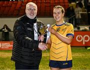 13 March 2025; DCU Dóchas Éireann captain Katelyn Rose Doherty is presented with the trophy by by Ladies HEC Chairperson, Daniel Caldwell, following her side's victory in the 2025 AIG Moynihan Cup final match between TUD CC1 and DCU Dóchas Éireann at Queen's University in Belfast. Photo by Shauna Clinton/Sportsfile