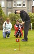 22 October 2004; Irish and Ryder Cup golf star Padraig Harrington putts at the opening of a new putting green at St Luke's Hospital, Rathgar, as Catherine Harrison, left, Ballina, and Catherine Moyles, Ballina, look on. The putting green will be used by patients of St Luke's, and their families, while undergoing treatment at the hospital. St. Luke's Hospital, Rathgar, Dublin. Picture credit; Brendan Moran / SPORTSFILE