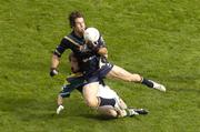 24 October 2004; Dean Solomon, Australia, is tackled by Brian McGuigan, Ireland. Coca Cola International Rules Series 2004, Second Test, Ireland v Australia, Croke Park, Dublin. Picture credit; Pat Murphy / SPORTSFILE *** Local Caption *** Any photograph taken by SPORTSFILE during, or in connection with, the 2004 Coca Cola International Rules Series which displays GAA logos or contains an image or part of an image of any GAA intellectual property, or, which contains images of a GAA player/players in their playing uniforms, may only be used for editorial and non-advertising purposes.  Use of photographs for advertising, as posters or for purchase separately is strictly prohibited unless prior written approval has been obtained from the Gaelic Athletic Association.