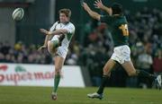 13 November 2004; Ronan O'Gara, Ireland, kicks for touch despite the attentions of De Wet Barry, South Africa. Rugby International, Ireland v South Africa, Lansdowne Road, Dublin. Picture credit; Brendan Moran / SPORTSFILE