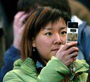 29 March 2005; A chinese supporter takes pictures on her mobile phone before the start of the game. International Friendly, Republic of Ireland v China, Lansdowne Road, Dublin Picture credit; David Maher / SPORTSFILE